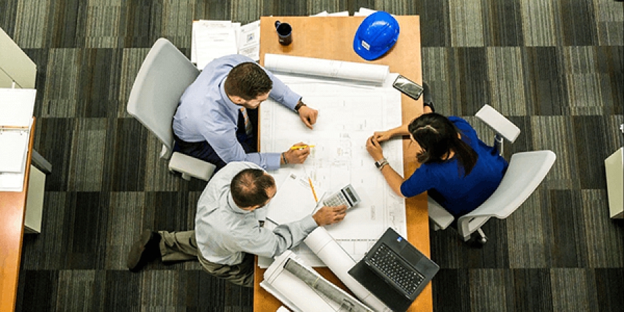 Team collaborating over project blueprints